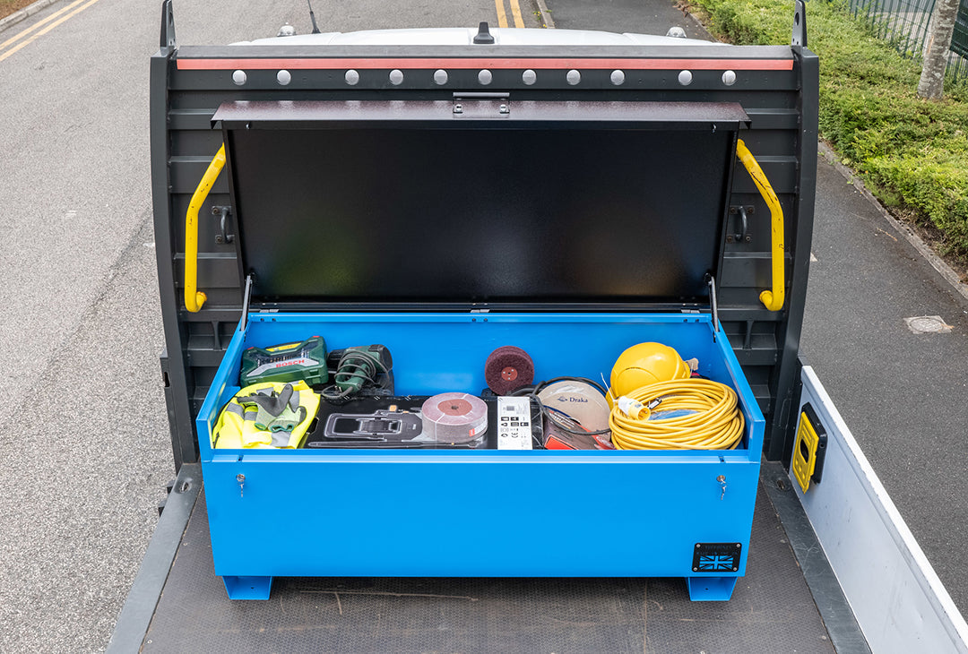 Large blue metal tool box chest with a range of electrical tools inside and a yellow hard hat. The toolbox is on the back of a pick up truck.