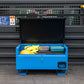 Blue metal tool box open with a range of electrical tools inside and a yellow hard hat. The toolbox is on top of a flat bed truck.