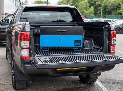 Blue metal tool box closed with a black lid on the back of a 4x4 pick up truck.